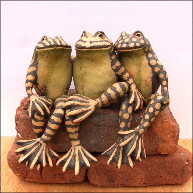 sculpture of three ceramic frogs