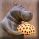 ceramic sculpture of a hippo offering a gift to his girlfrend.