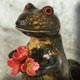 sculpture d'un lézard qui tient un bouquet de fleurs